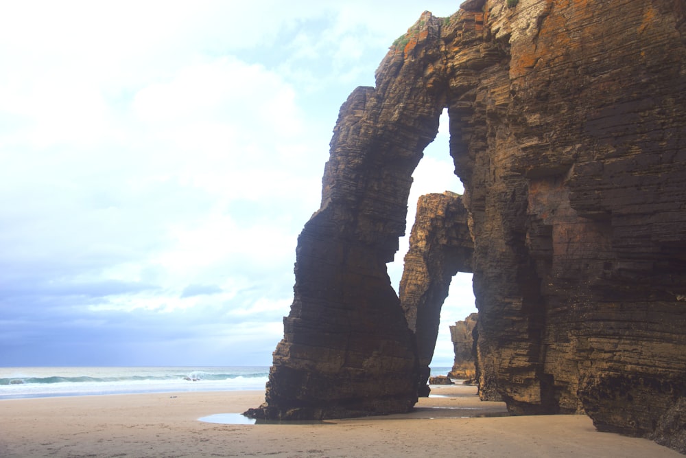 Una grande formazione rocciosa su una spiaggia vicino all'oceano