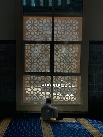 Portrait of Sudhir Kumar Jha in a serene, elegant setting with gold and navy accents.