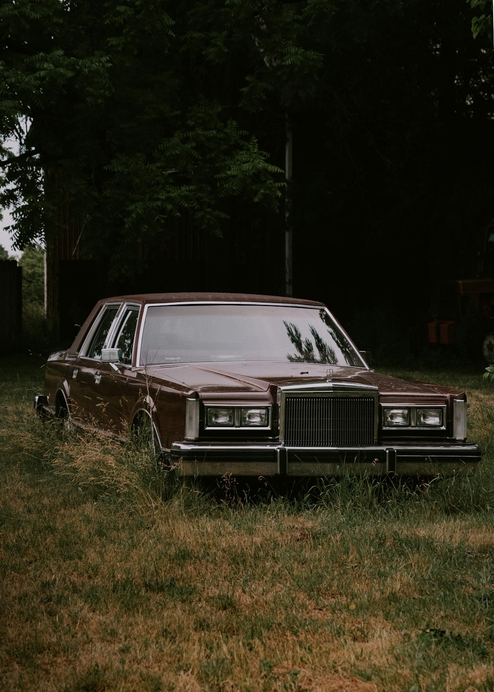 a brown car parked in a field of grass