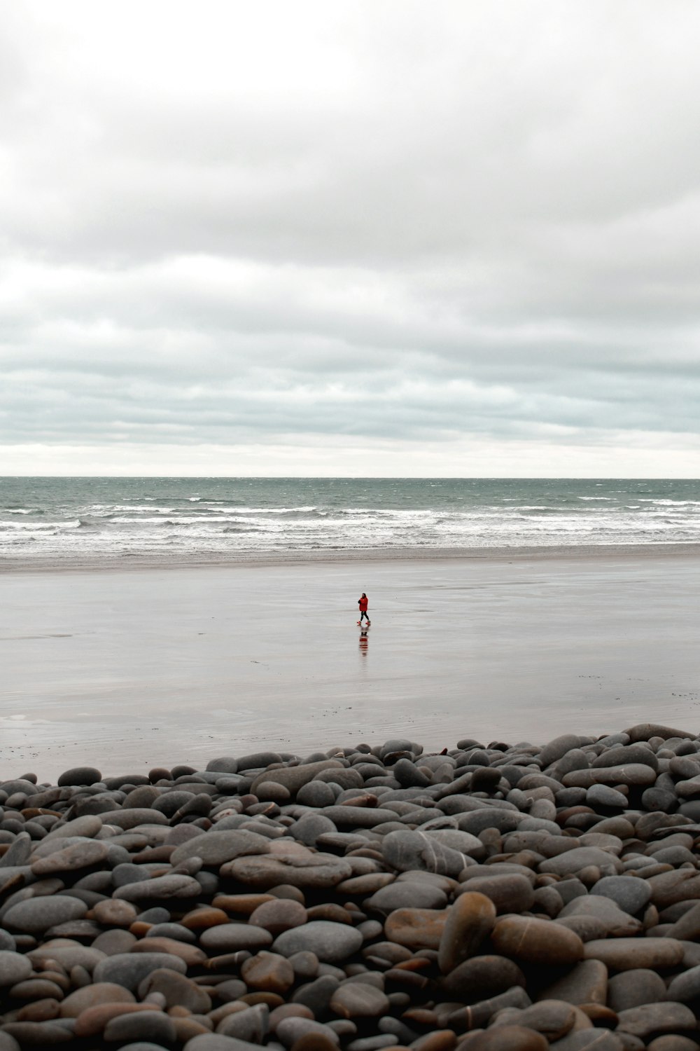 a person standing on a beach next to the ocean