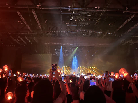 A-lanna performing on stage under warm amber lights, with a captivated audience in the background.