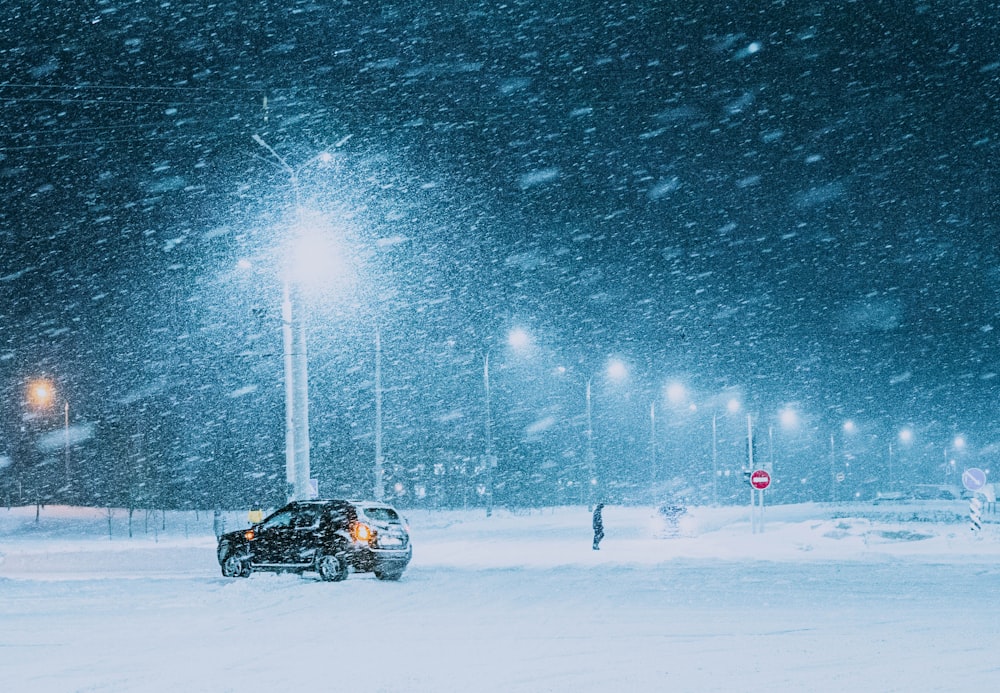 a car parked on a snowy street at night