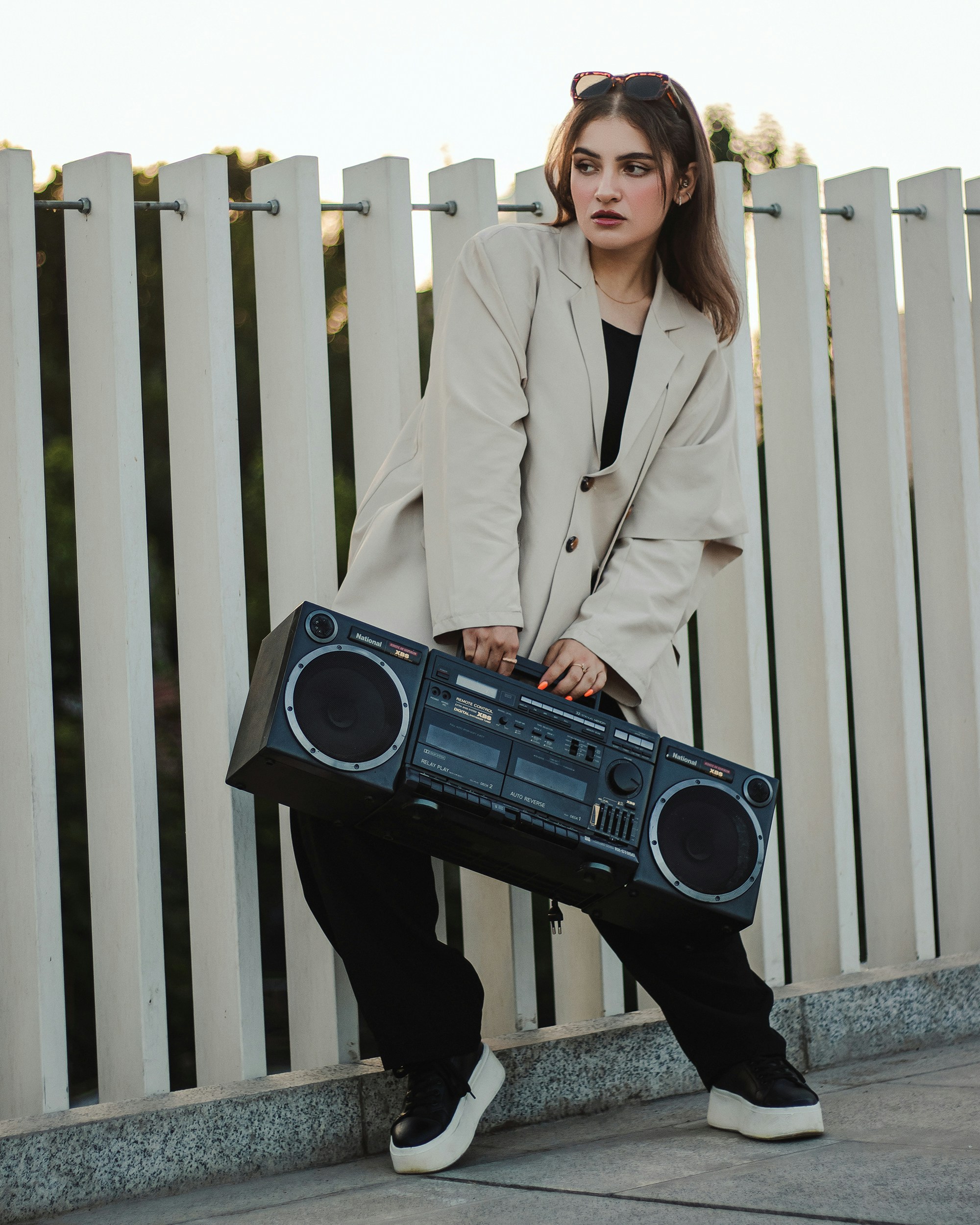 a woman is holding a boombox and posing for a picture