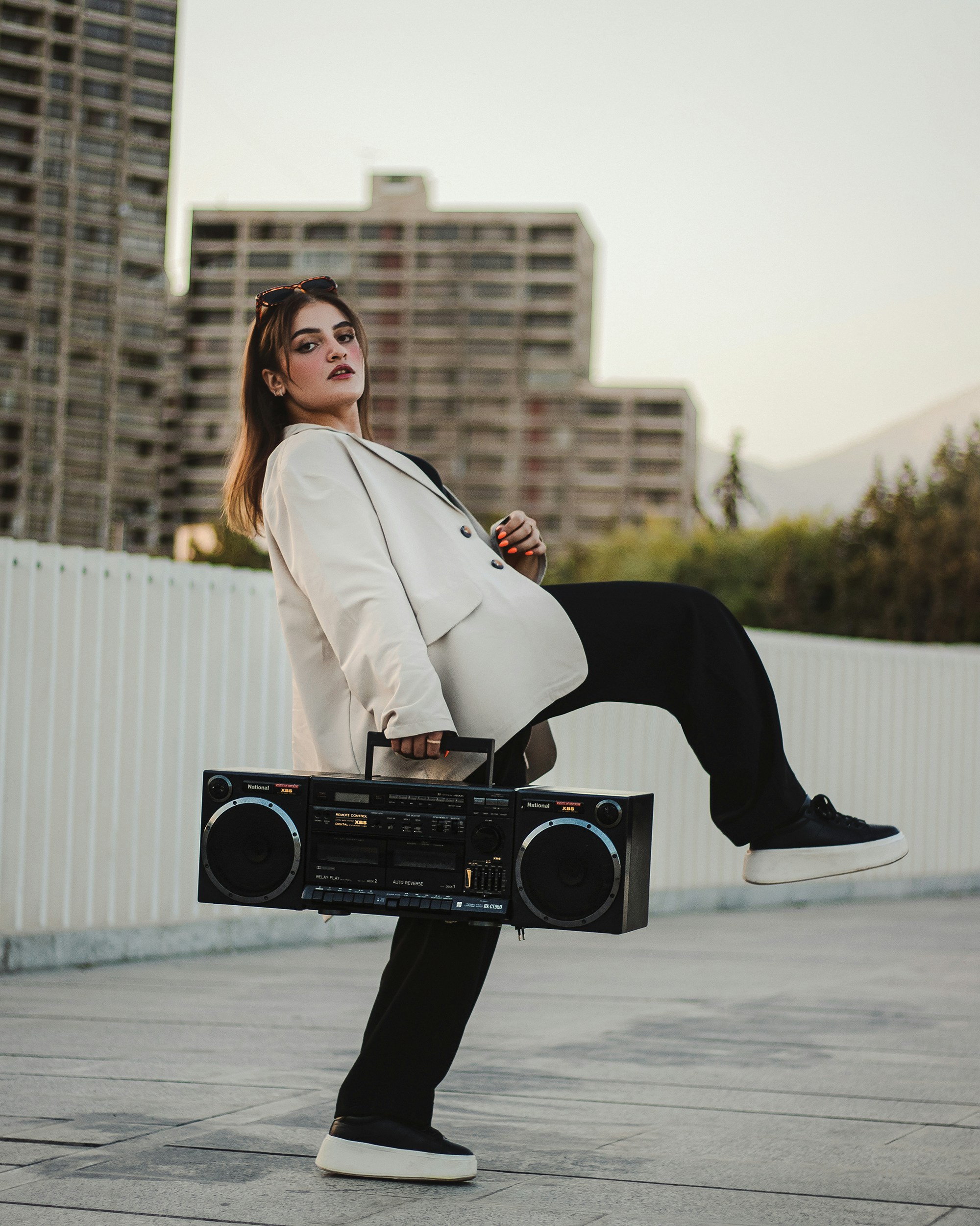 a woman sitting on top of a boom box