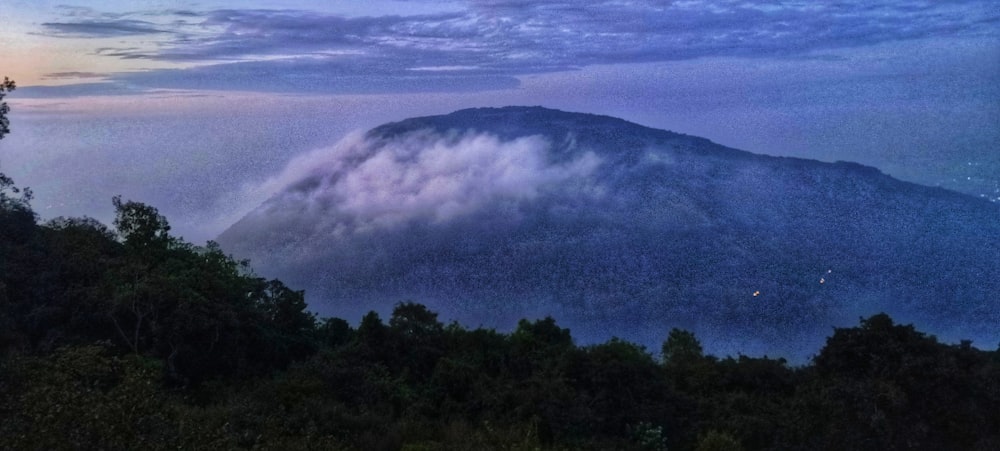 a view of a mountain covered in clouds