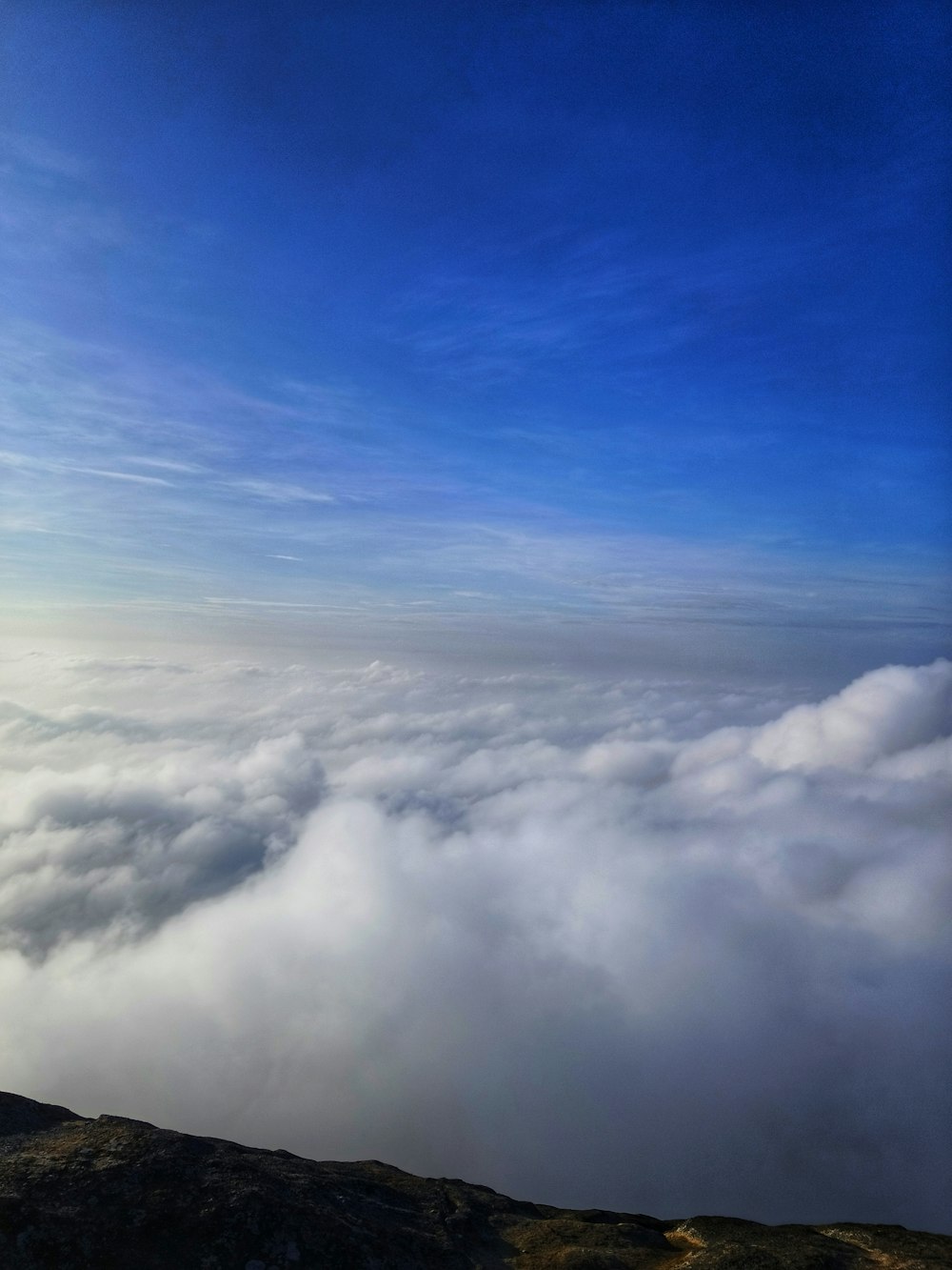 a view of the clouds from the top of a mountain