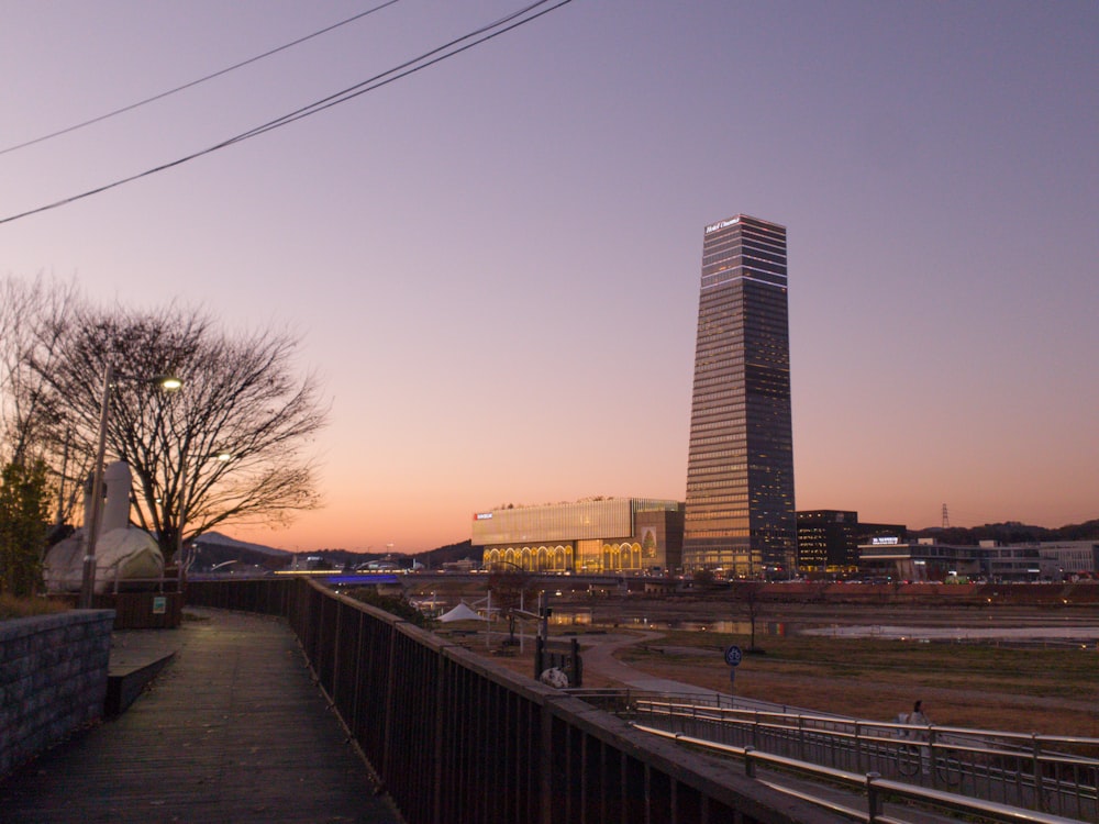 a tall building sitting next to a river under a purple sky
