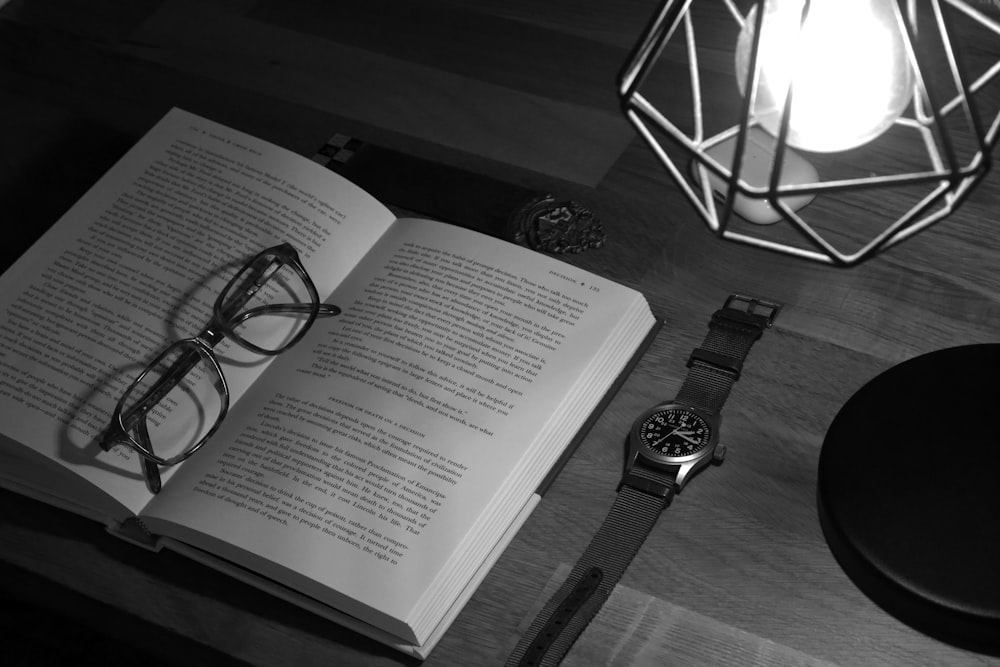 an open book and a pair of glasses on a table