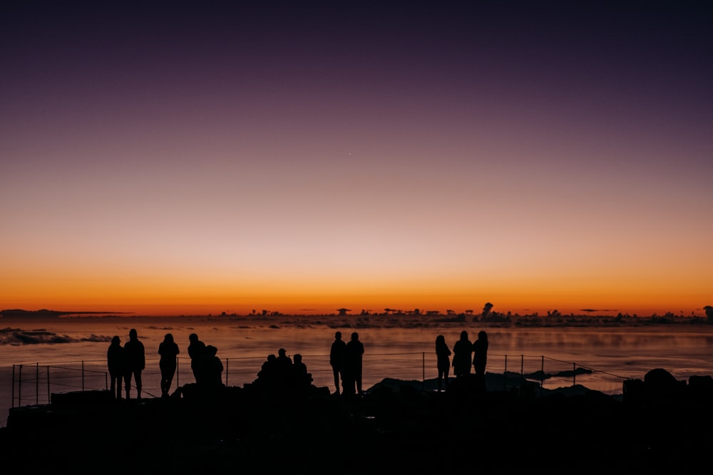 a group of people standing next to a body of water