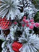 A winter-inspired arrangement with pine branches, red berries, and white carnations.