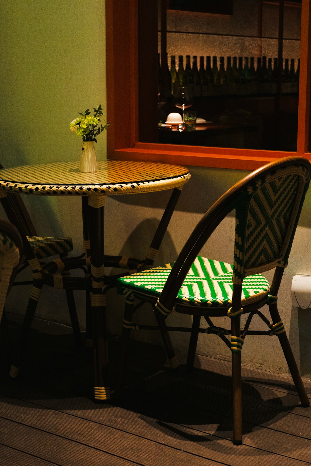 a table and chair with a vase of flowers on top of it