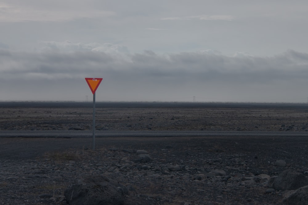 a red and yellow street sign sitting on the side of a road