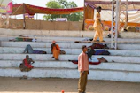 Pilgrims resting peacefully in shaded areas after a day of rituals.