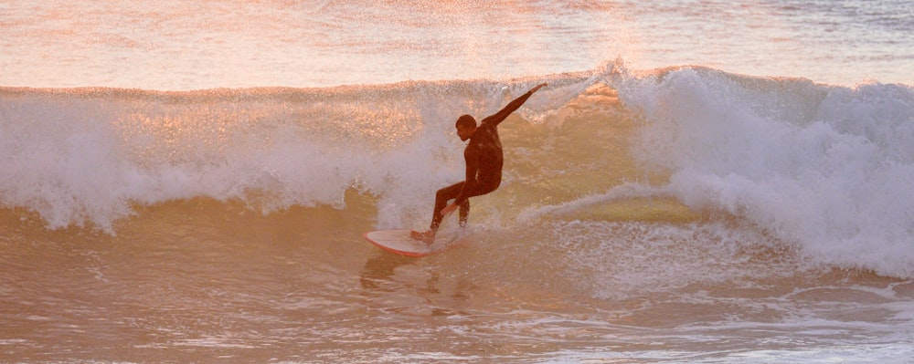 a man riding a wave on top of a surfboard