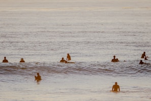 Group of surfers laughing and sharing stories on their boards near Imsouane’s famous bay