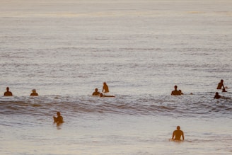 Group of surfers laughing and sharing stories on their boards near Imsouane’s famous bay