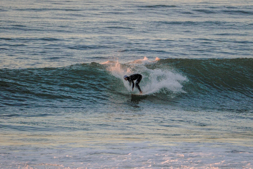 Un hombre montando una ola encima de una tabla de surf