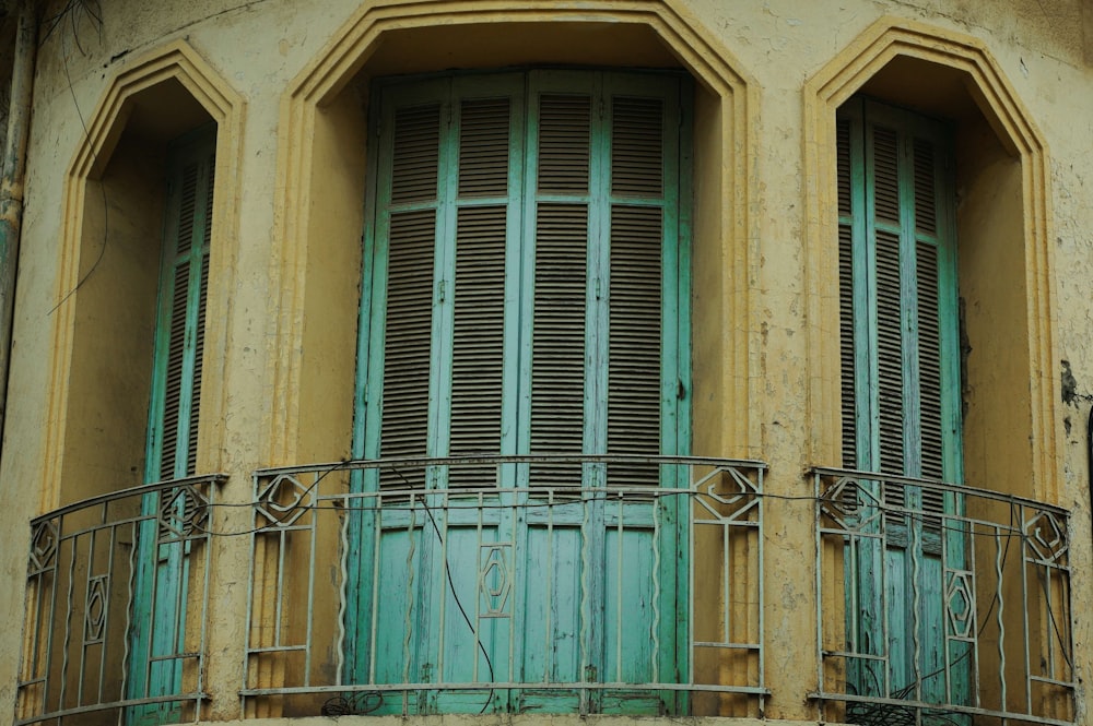 a blue and yellow building with green shutters