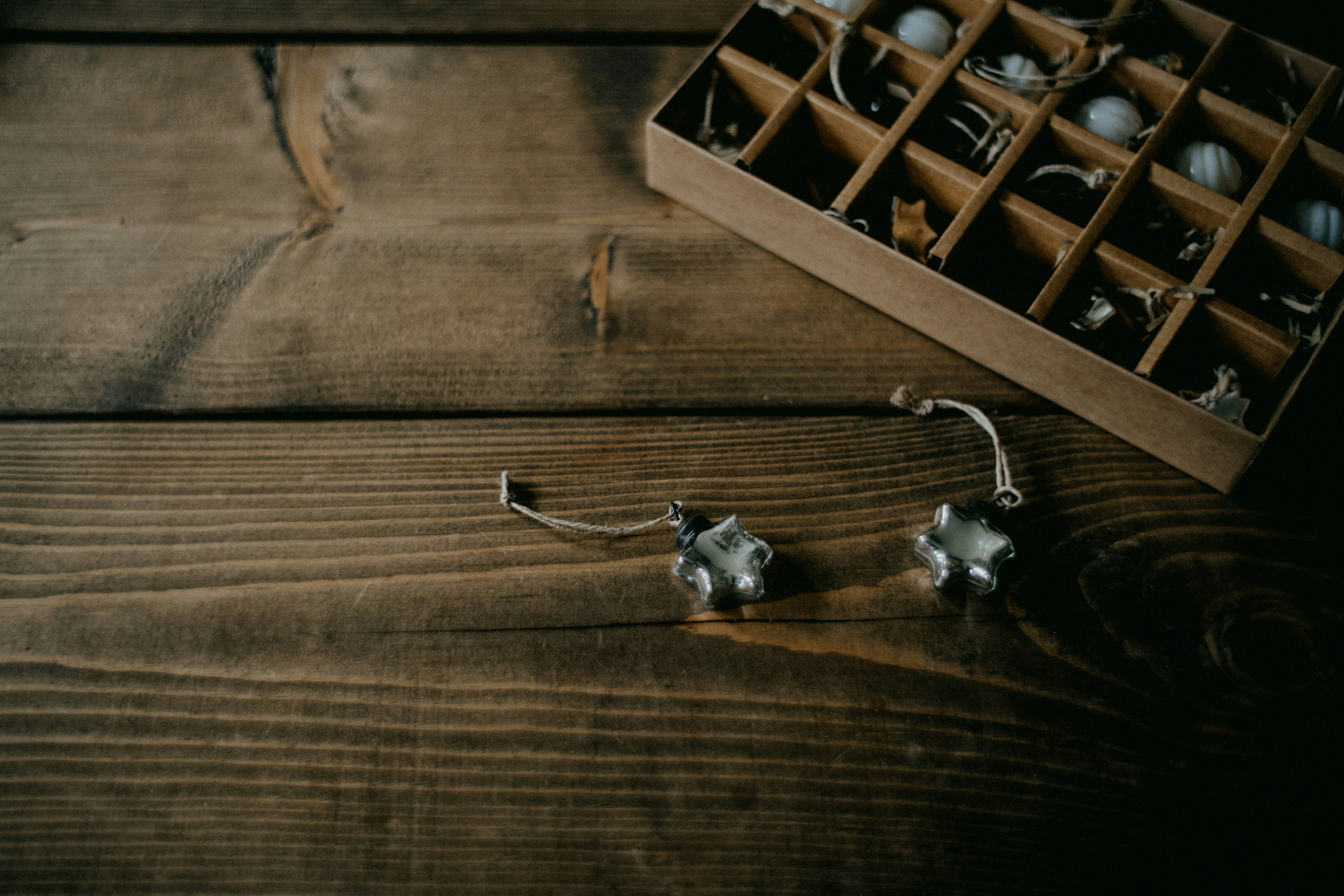 a pair of earrings sitting on top of a wooden table