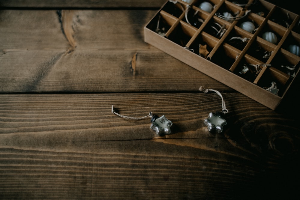 ein Paar Ohrringe, die auf einem Holztisch sitzen