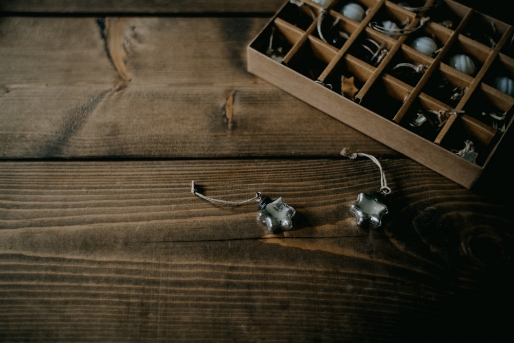 a pair of earrings sitting on top of a wooden table