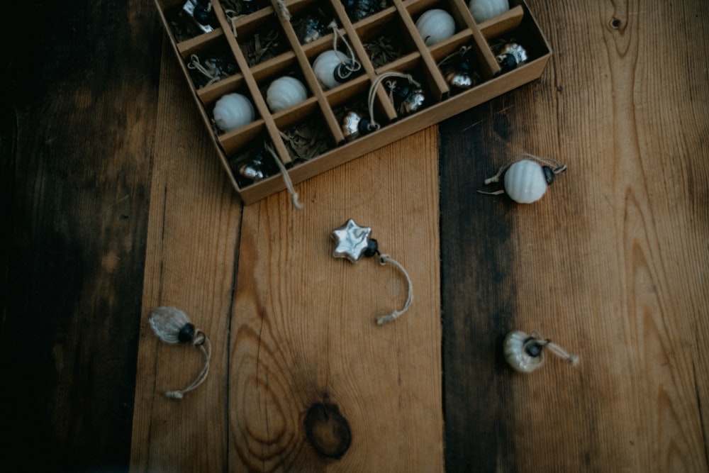uma caixa cheia de ornamentos em cima de um piso de madeira