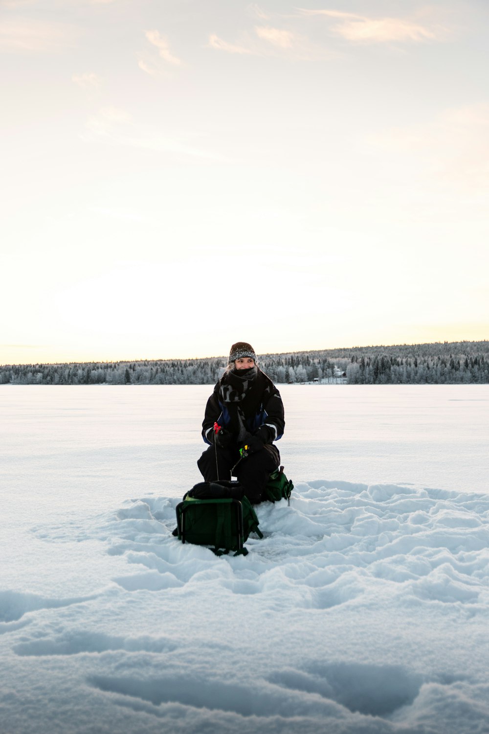 a man sitting on top of a snow covered field