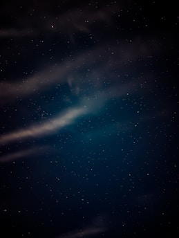 A serene night sky filled with stars, casting a soft glow over a tranquil landscape.