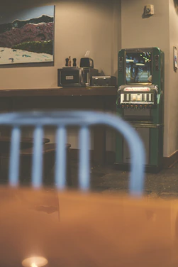 A modern vending machine with glowing electric green accents in a stylish office breakroom.