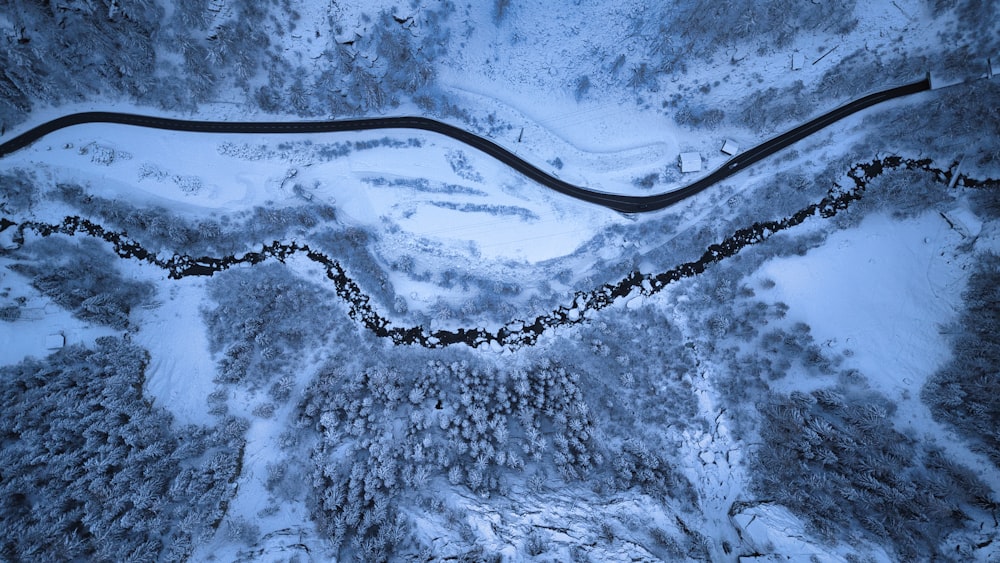 an aerial view of a winding road in the snow