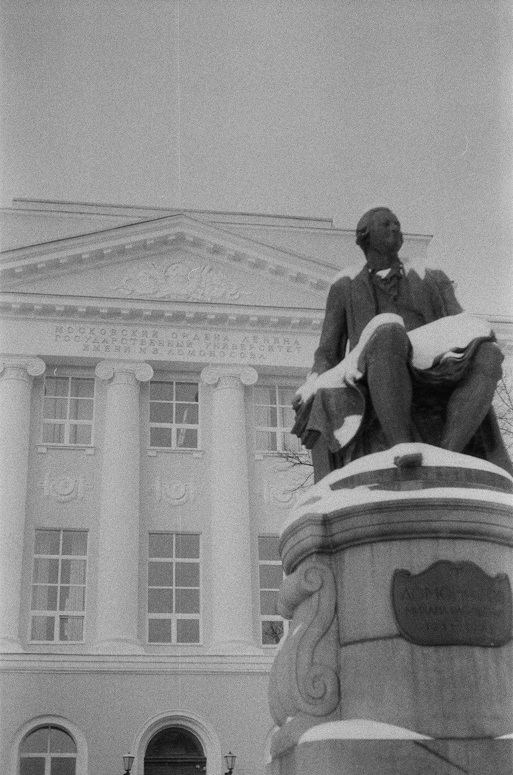 a black and white photo of a statue in front of a building