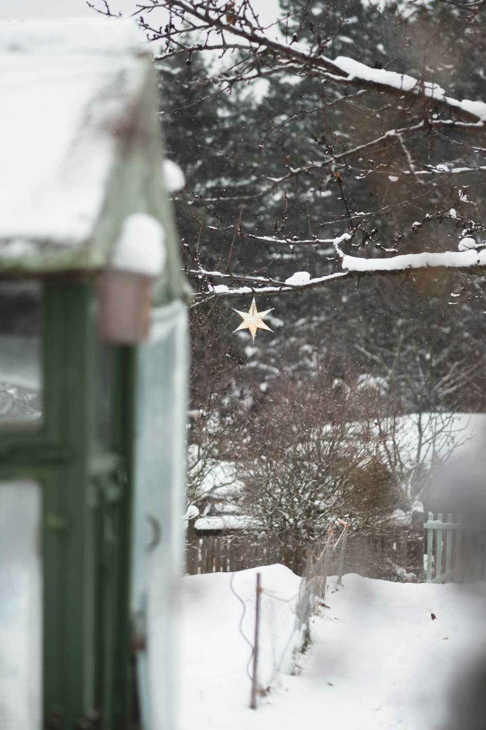 a green mailbox with a star hanging from it's side