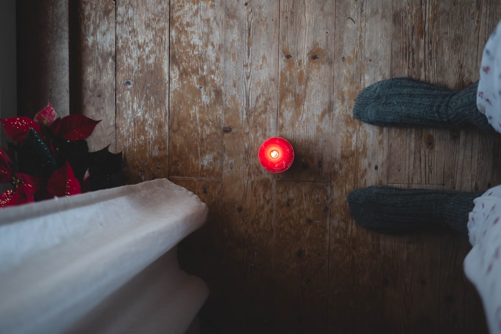 a red light sitting on the side of a wooden wall