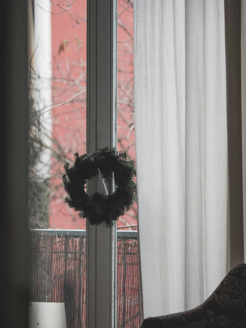 a wreath on a window sill in front of a window