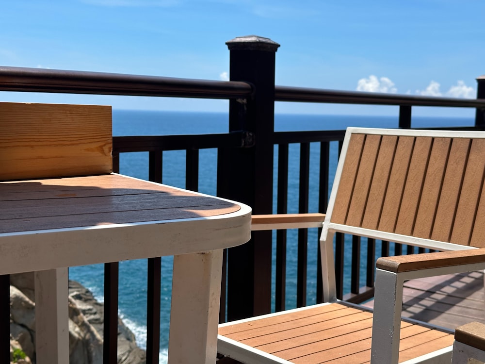 two wooden chairs sitting on top of a wooden deck