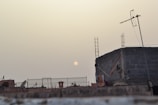 Technician installing fiber optic cables on a rooftop at sunset