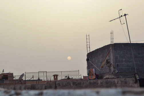 A filmmaker directing a scene on a bustling urban rooftop at sunset.