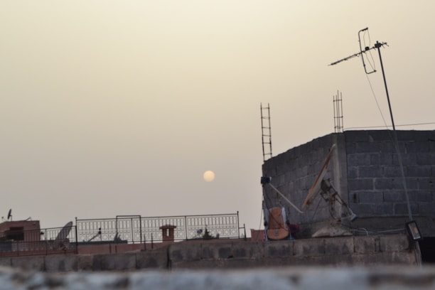 Technicians installing fiber optic cables on a rooftop at sunset.