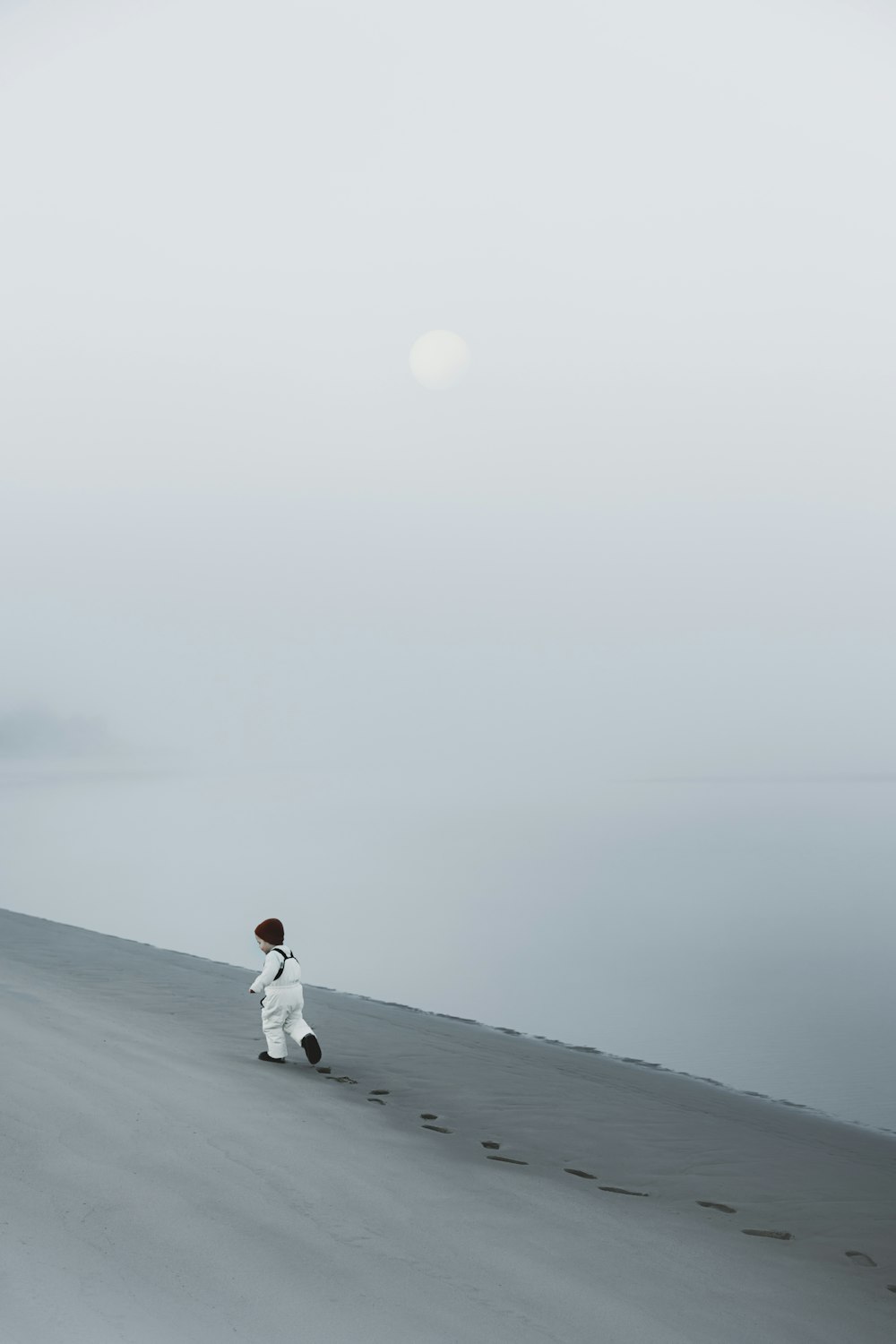 a person in white is walking on a beach