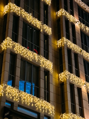 Festive holiday lighting draped elegantly over a high-end commercial building’s facade in Montreal.