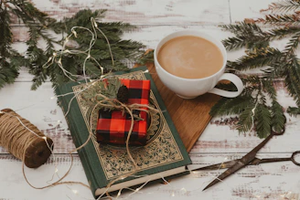 A neatly wrapped present with a rustic bow beside a steaming cup of coffee.