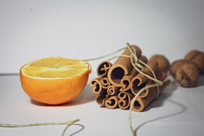 an orange and some cinnamons on a table