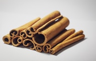 a pile of cinnamon sticks sitting on top of a white table