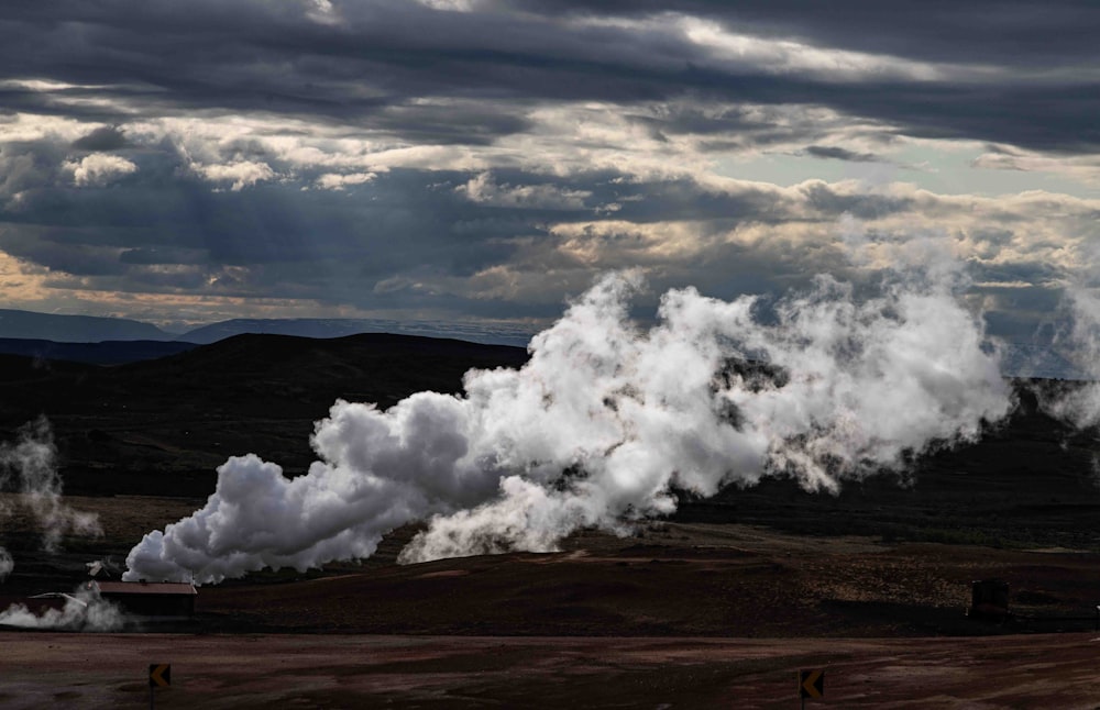 a large group of steam rises from the ground