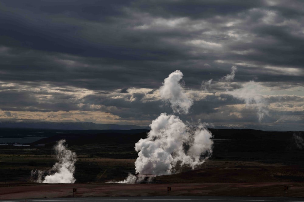 a large plume of steam rises from the ground