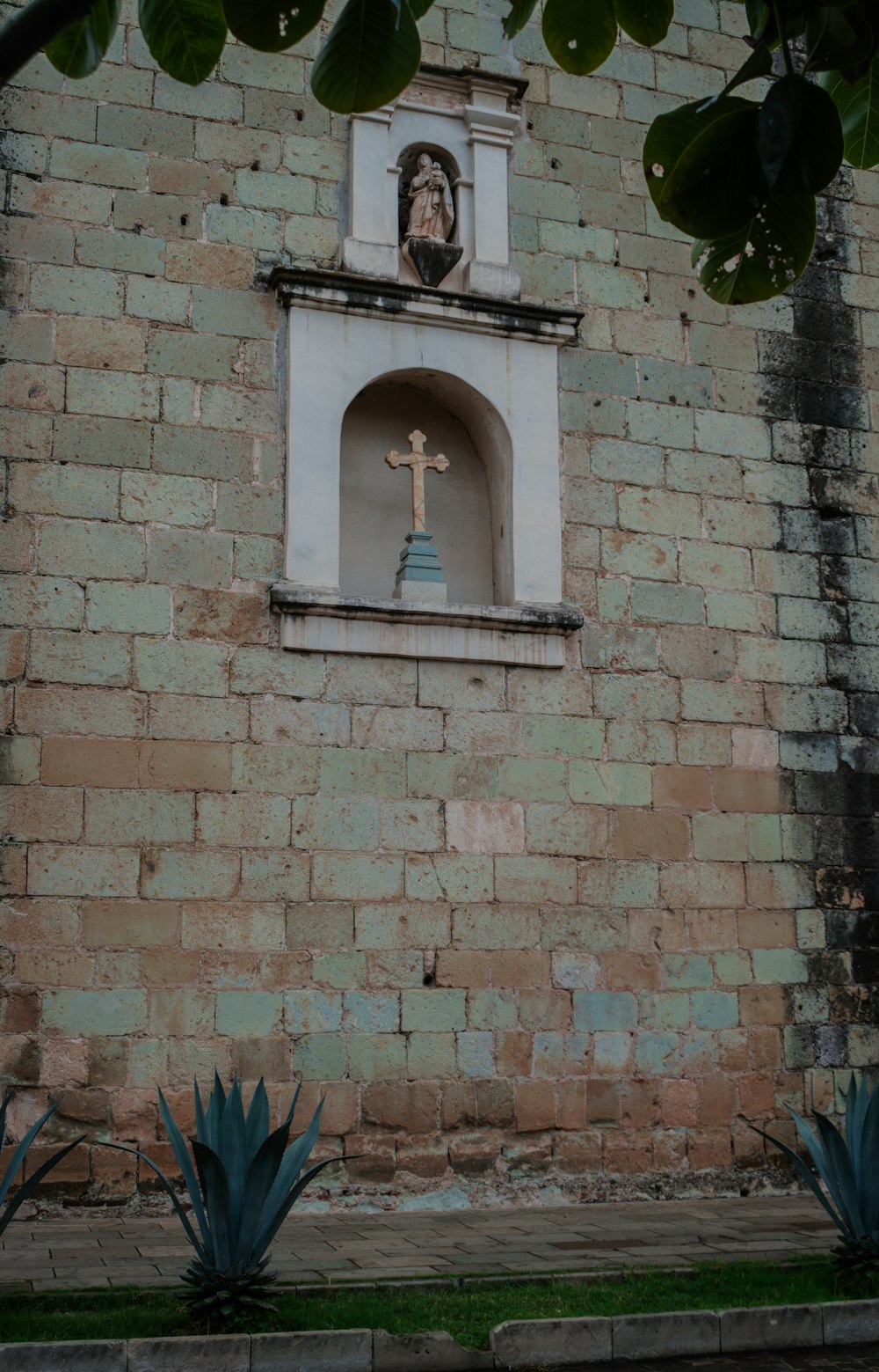 a brick wall with a statue of a person on it