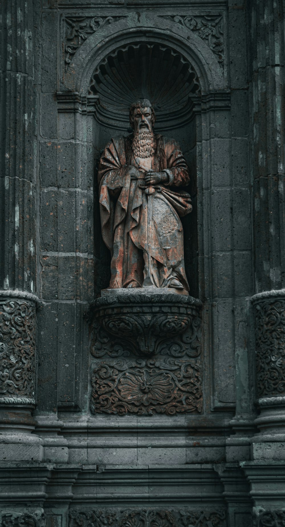 a statue of a man holding a cross on a building