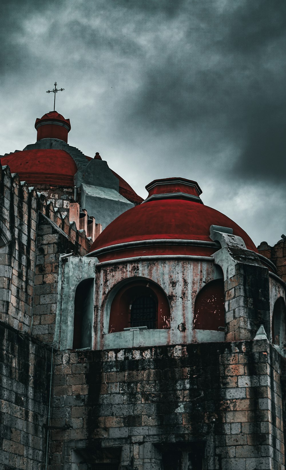 a red dome on top of a building under a cloudy sky