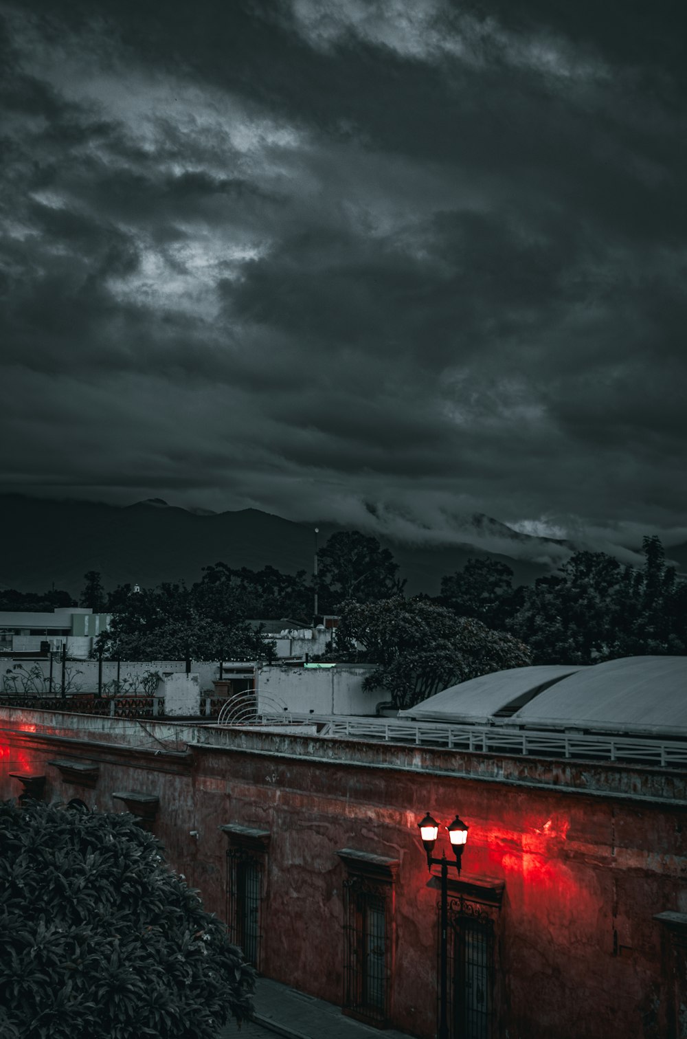 a building with red lights in front of a cloudy sky