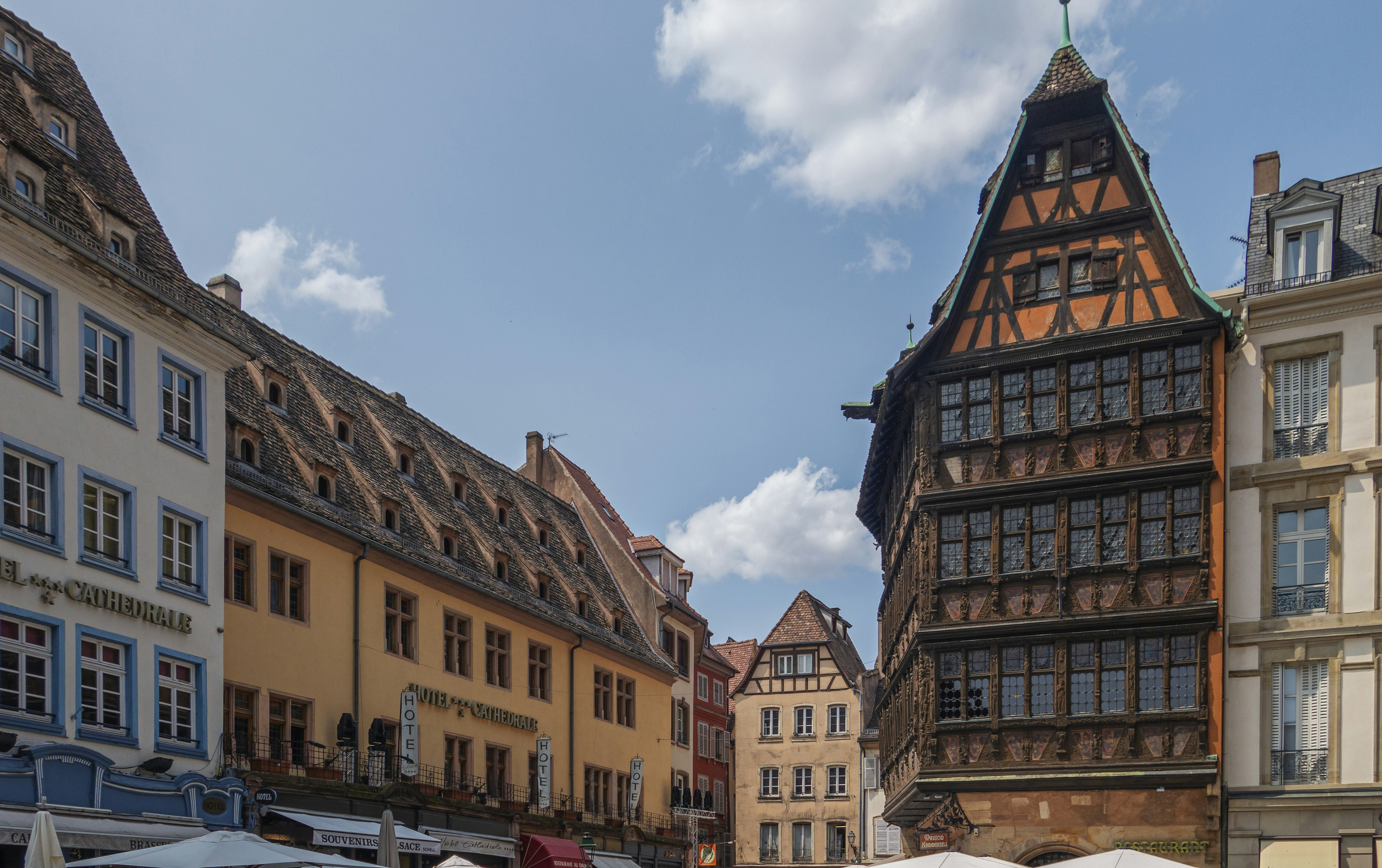 a group of people walking down a street next to tall buildings, 